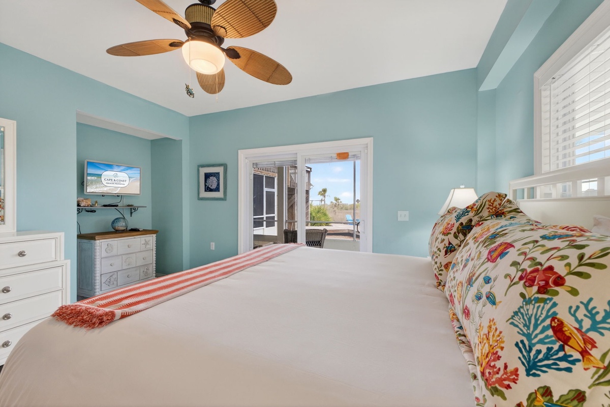 Drift off to sleep in this serene coastal bedroom with tropical ceiling fan and ocean glimpses through your balcony doors.