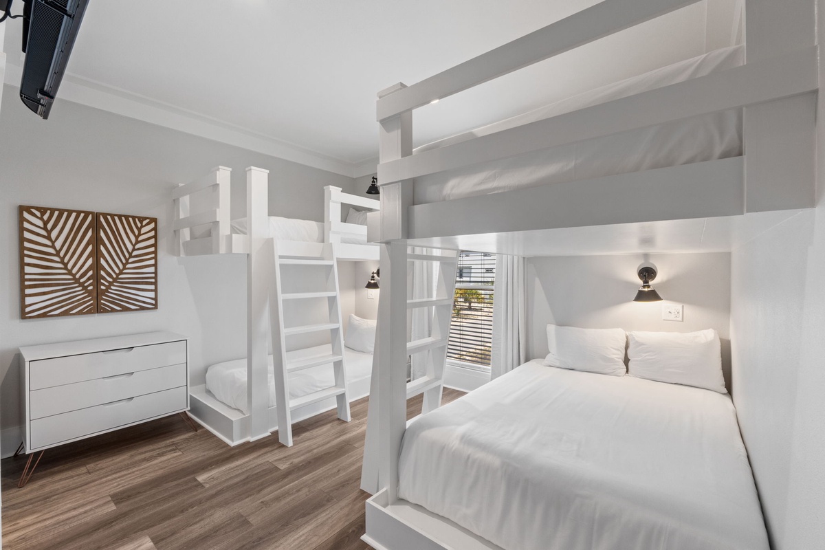 Ideal for families, this bright bedroom features twin bunk beds with crisp linens and a cozy lower double bed—perfect for kids and adults alike. Natural light pours in, creating your own restful retreat.