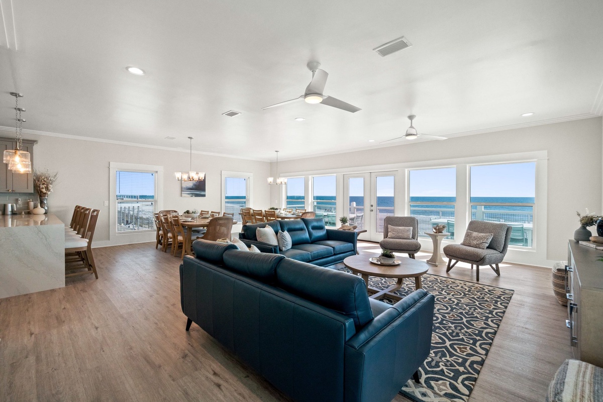 Relax in your stunning oceanfront living space where panoramic sea views stretch endlessly beyond floor-to-ceiling windows, creating the perfect coastal retreat.