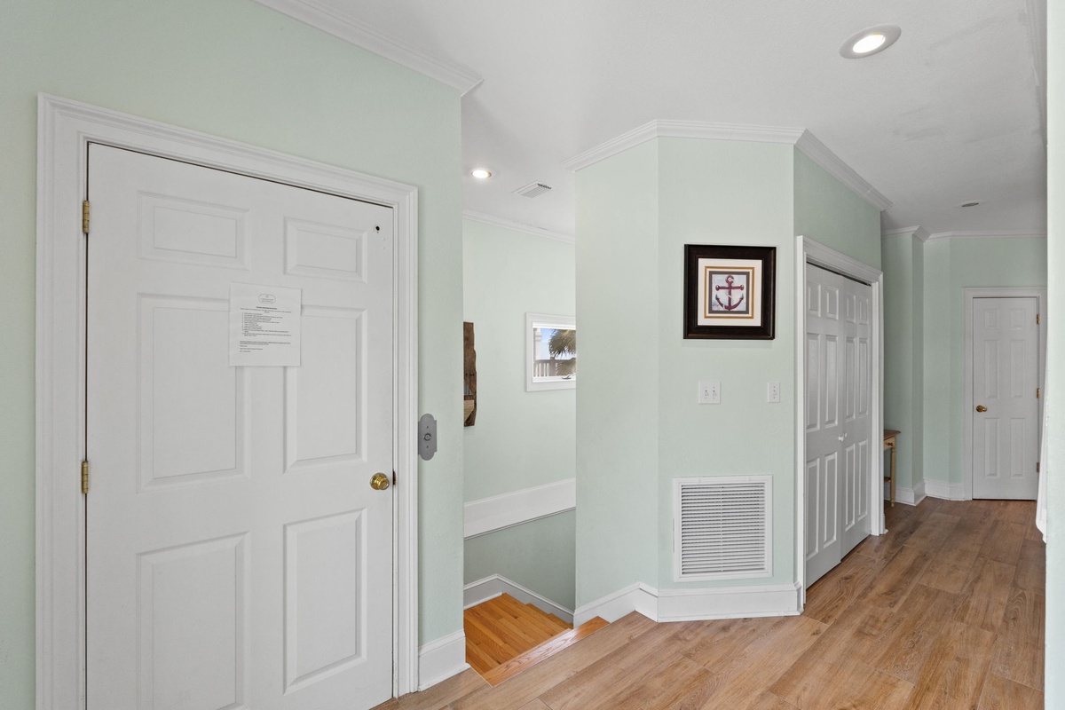 Step into your coastal haven where sea-glass green walls and warm hardwood floors create a welcoming atmosphere throughout your spacious vacation home.