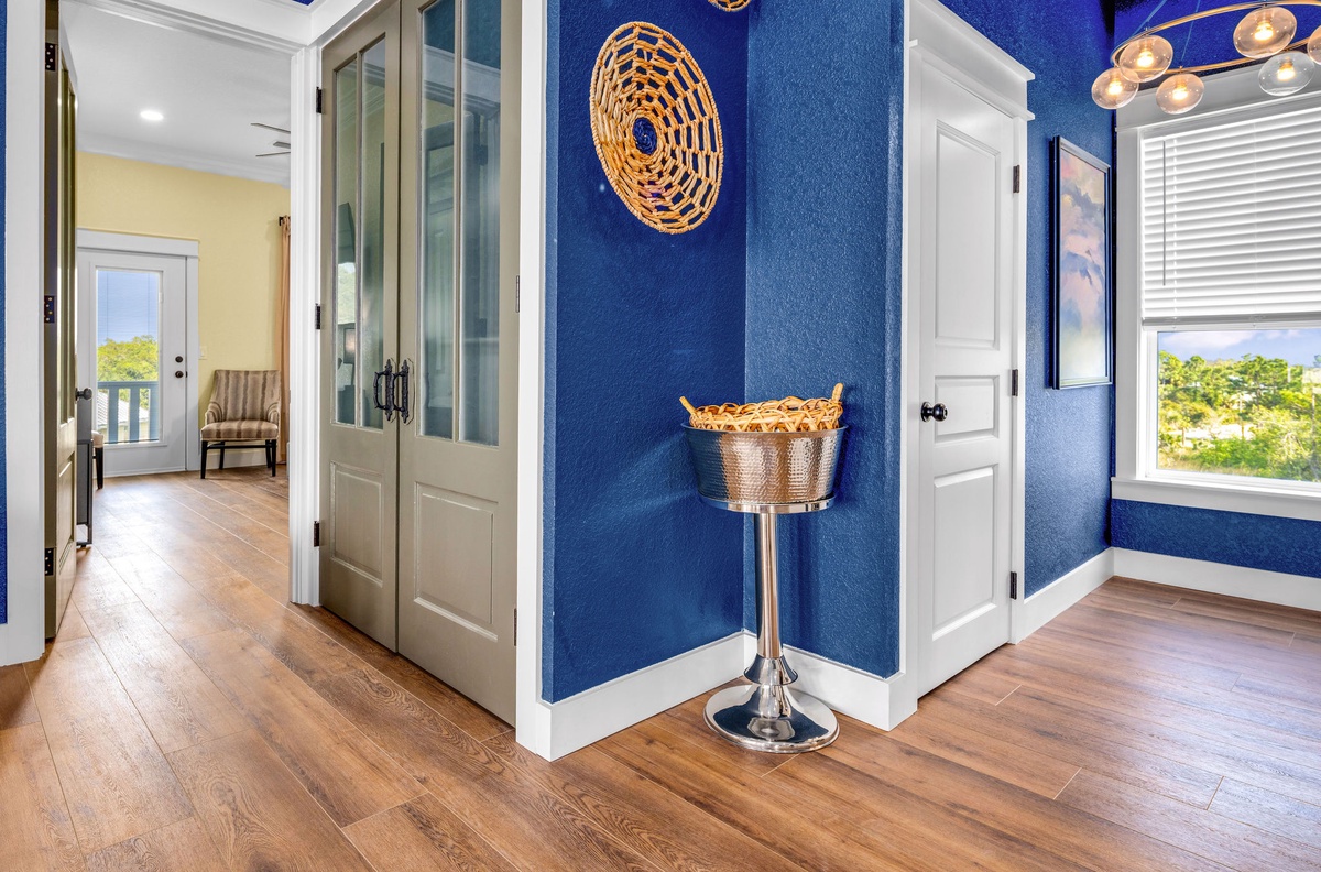 Stylish entryway with stunning blue walls welcomes you home after your coastal adventures.