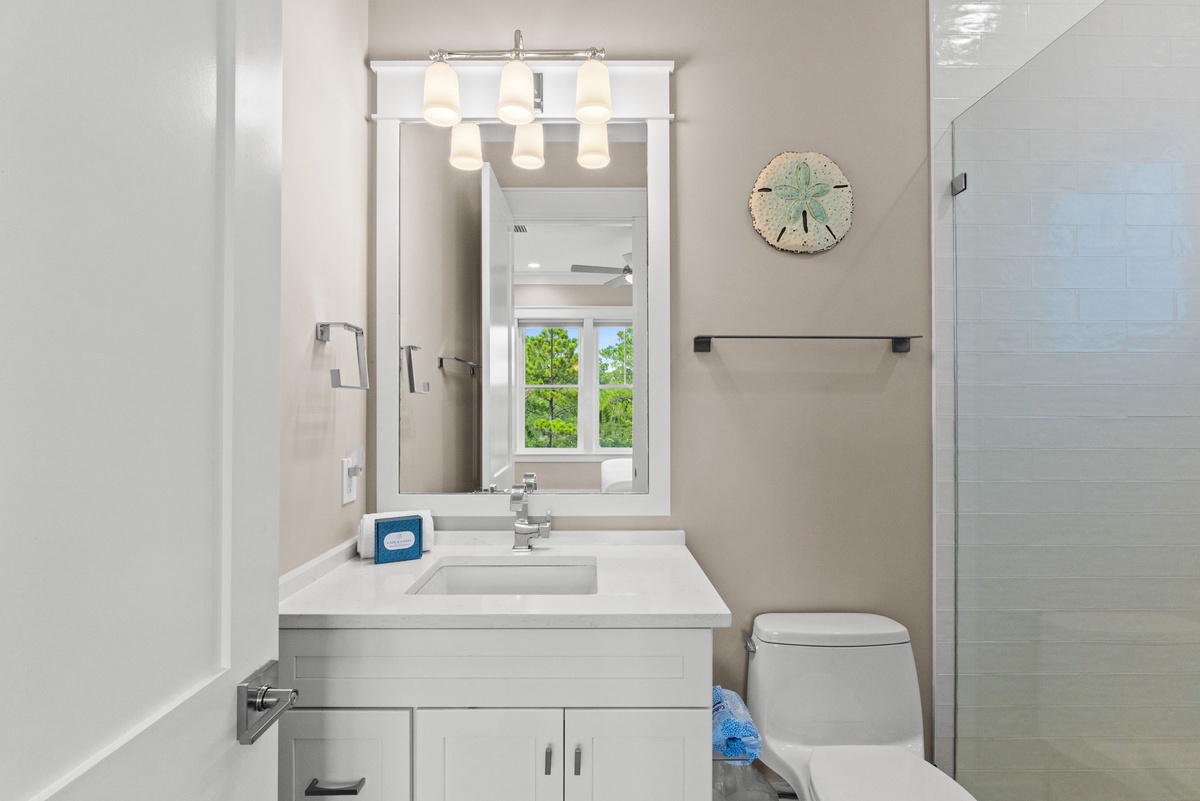 Step into your spotless coastal-inspired bathroom, where soft neutral tones and beach-themed décor create a calming retreat after a day of adventure.