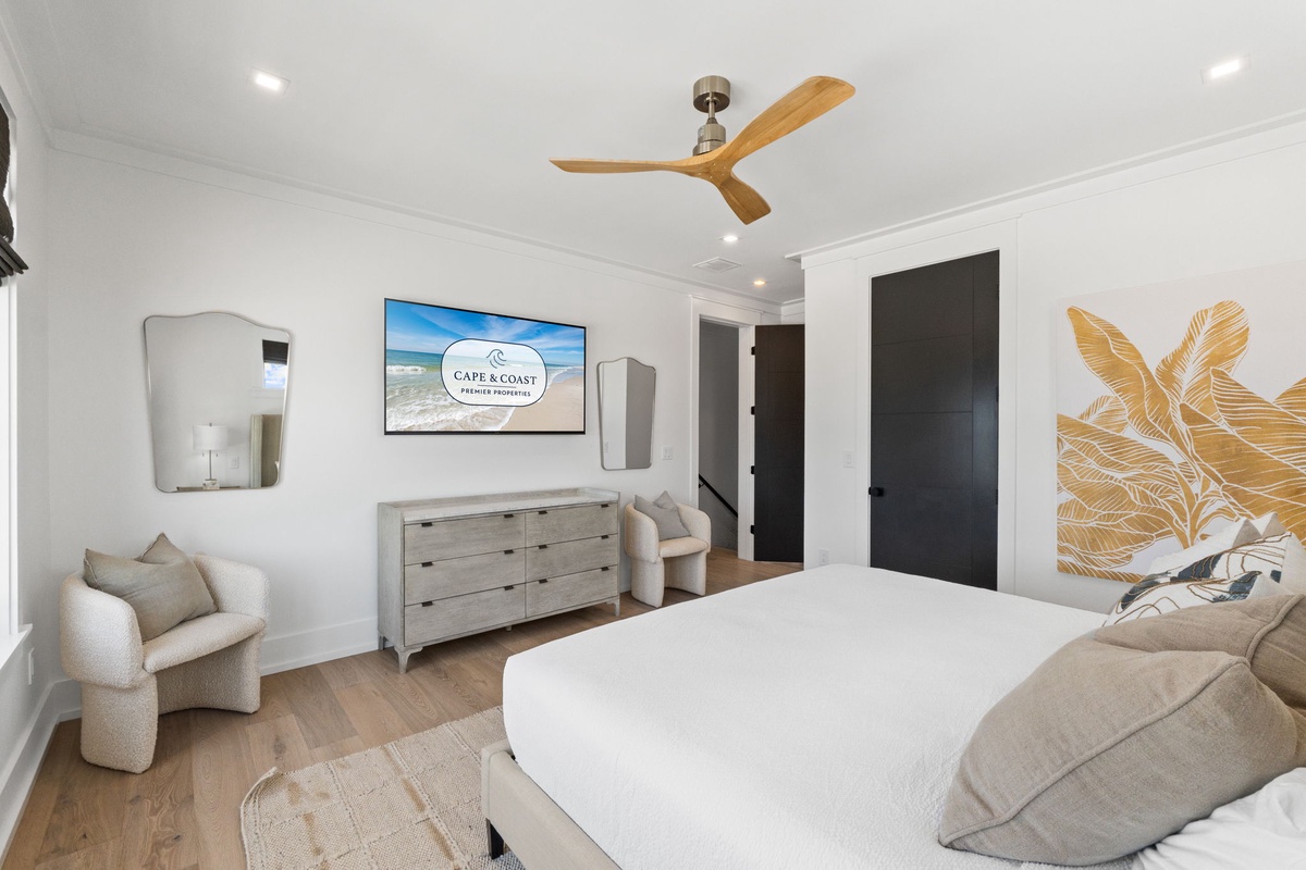 Sink into crisp linens and coastal style in this serene bedroom, complete with ceiling fan and elegant accents to enhance your stay.