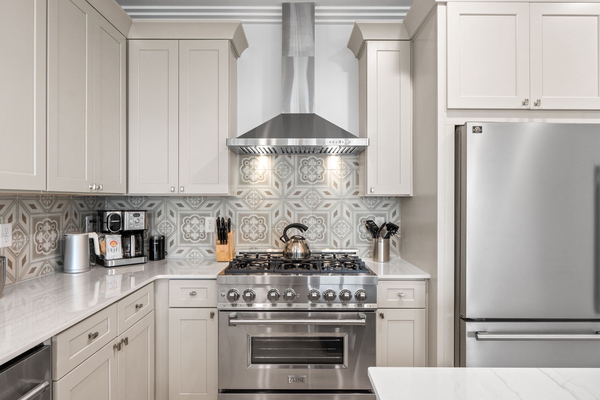 Step into your gourmet kitchen where stainless steel appliances and elegant tilework create the perfect space for preparing memorable meals during your stay.