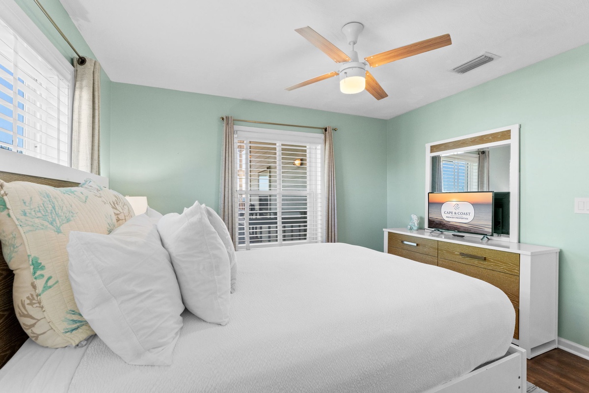 Drift off peacefully in your serene bedroom with soft mint walls, crisp linens, and gentle ceiling fan creating perfect comfort.