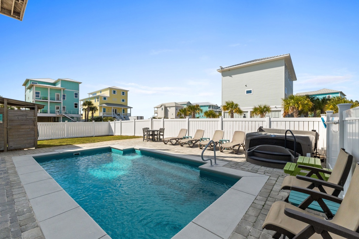 Dive into your private pool paradise surrounded by colorful beach houses, where sun loungers await your afternoon relaxation.