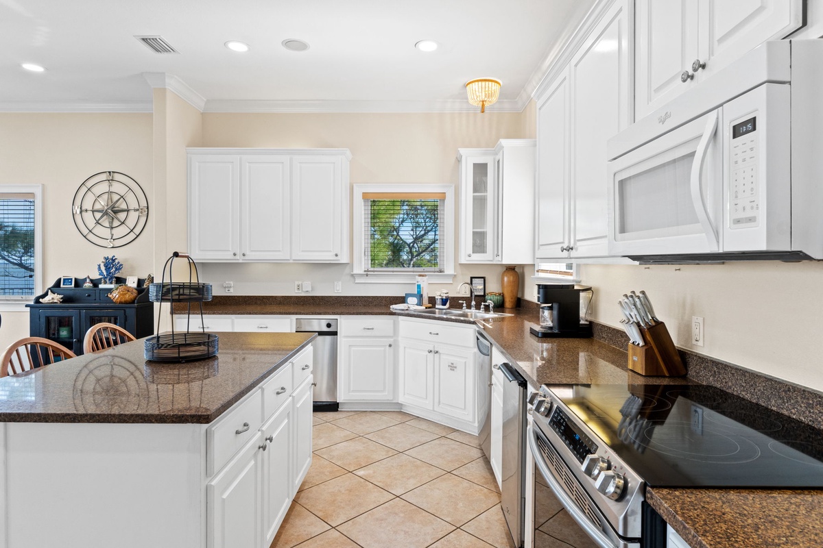 Step into your spacious gourmet kitchen where granite counters and white cabinetry create the perfect space for memorable meals together.