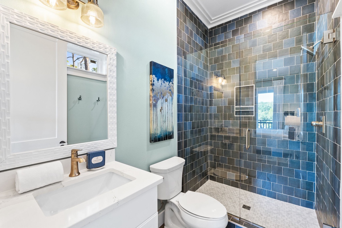 Luxurious bathroom featuring stunning glass-enclosed shower with colorful mosaic tiles, creating your perfect private spa retreat.