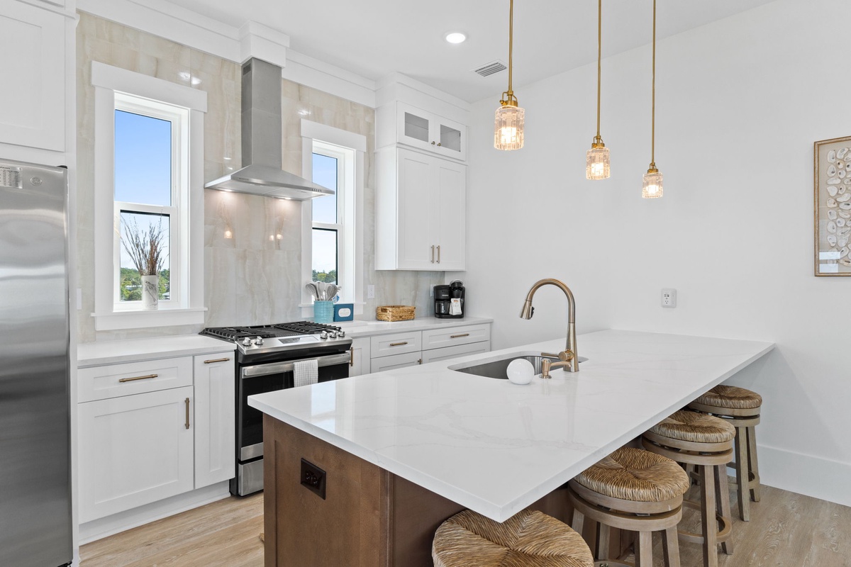 Your gourmet kitchen invites culinary adventures with gleaming quartz counters, professional appliances, and warm pendant lighting creating the perfect atmosphere.