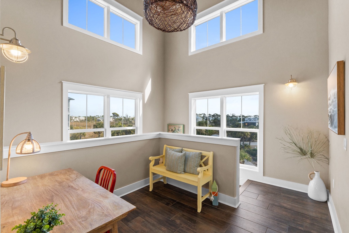 Natural light floods your dining space through soaring windows, creating the perfect spot for morning coffee or evening conversations.