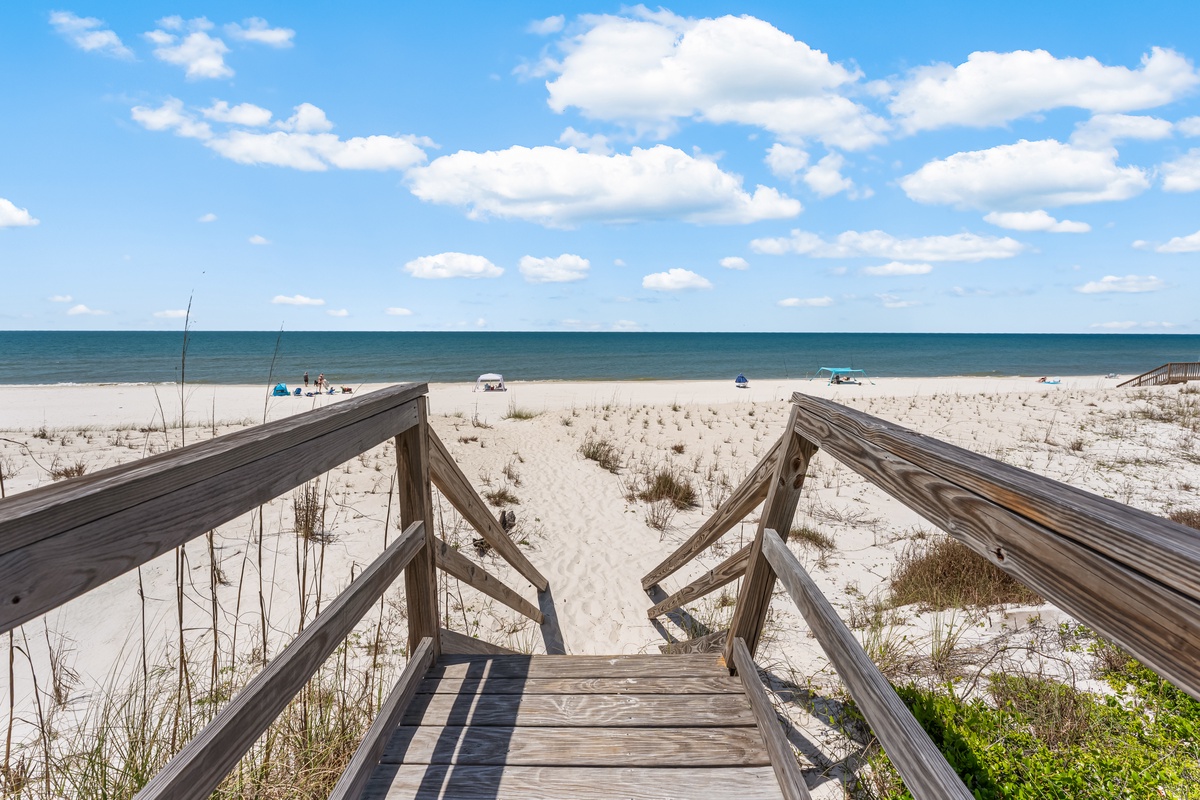 Wooden boardwalk leads directly to pristine white sand beach and turquoise waters, offering easy access to your coastal paradise.