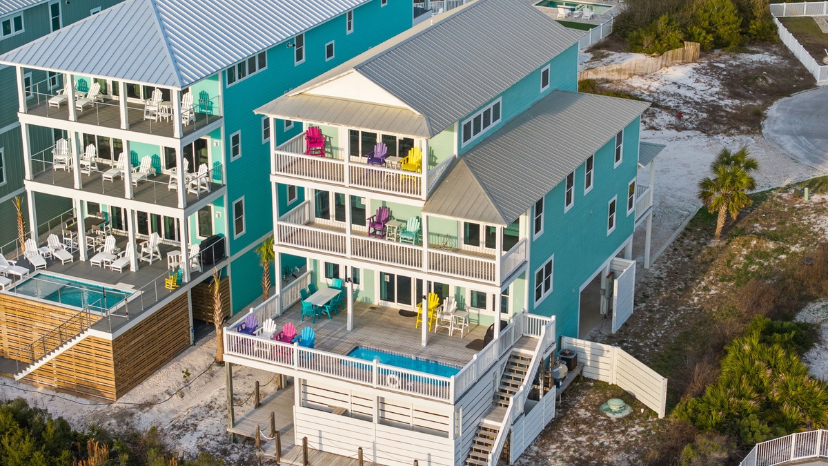 Bright turquoise beach houses with private pools and sunny balconies create the perfect coastal getaway setting.