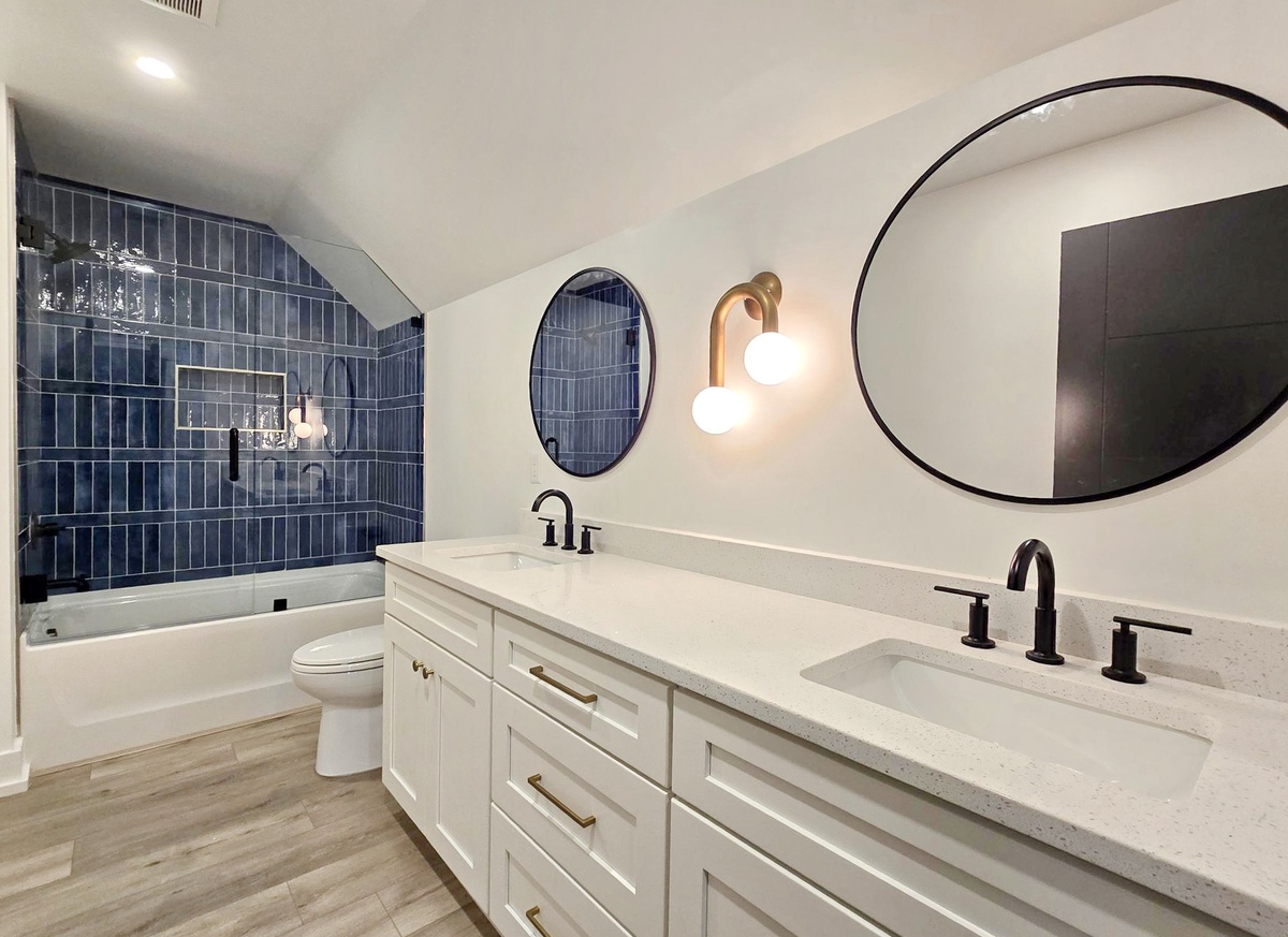 Unwind in your spa-like bathroom featuring dual vanities, luxurious soaking tub, and stunning blue subway tile shower.