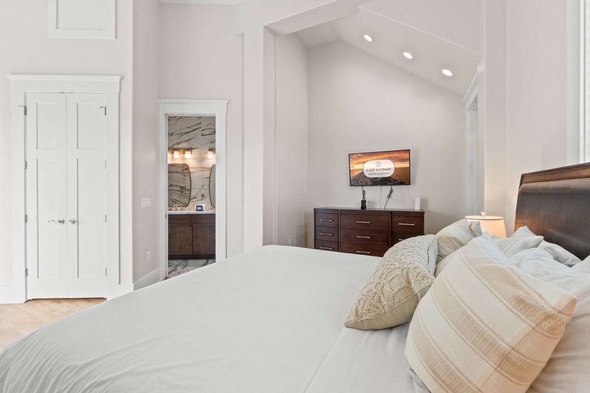 Sink into plush bedding in your spacious master suite, where vaulted ceilings and warm wood accents create the perfect retreat.