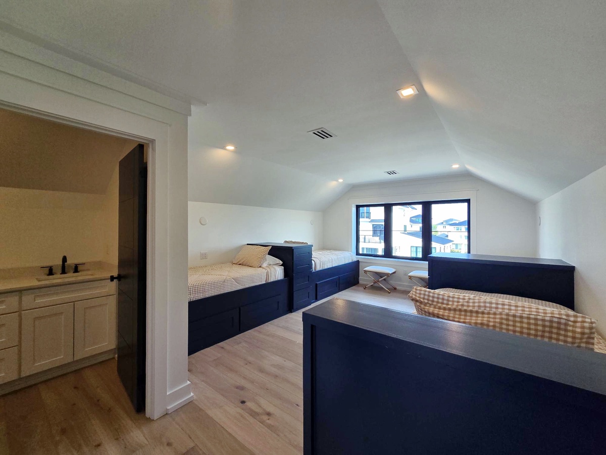Cozy attic bedroom with built-in beds and city views - your perfect retreat under the slanted ceiling.
