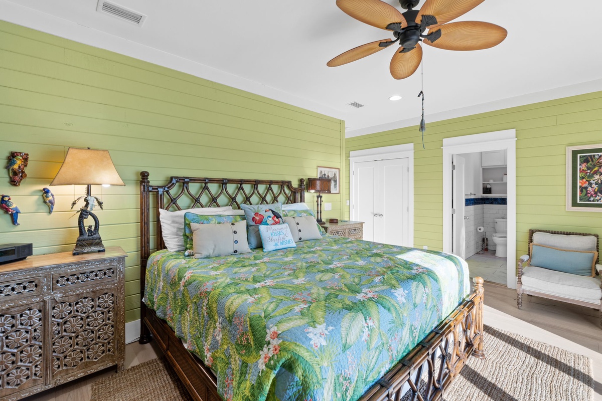Your tropical bedroom retreat features cheerful green walls, comfortable seating, and an en-suite bathroom for ultimate convenience and relaxation.