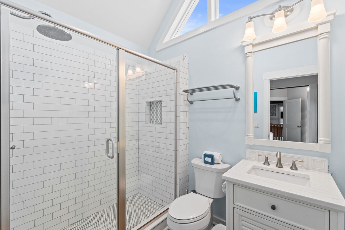 Step into a spotless bathroom with crisp white subway tiles, a spacious walk-in shower, and soft blue walls that bring calm to your daily routine.