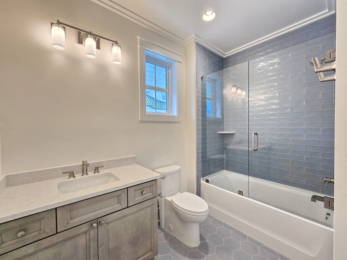 Refresh in your elegant bathroom featuring a luxurious soaking tub, sleek subway tile shower, and beautiful natural lighting from the window.