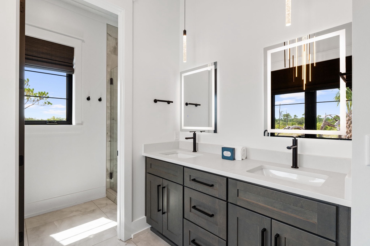 Refresh in your modern double-vanity bathroom, where sleek fixtures, lighted mirrors, and natural light create a serene space to start and end your day.