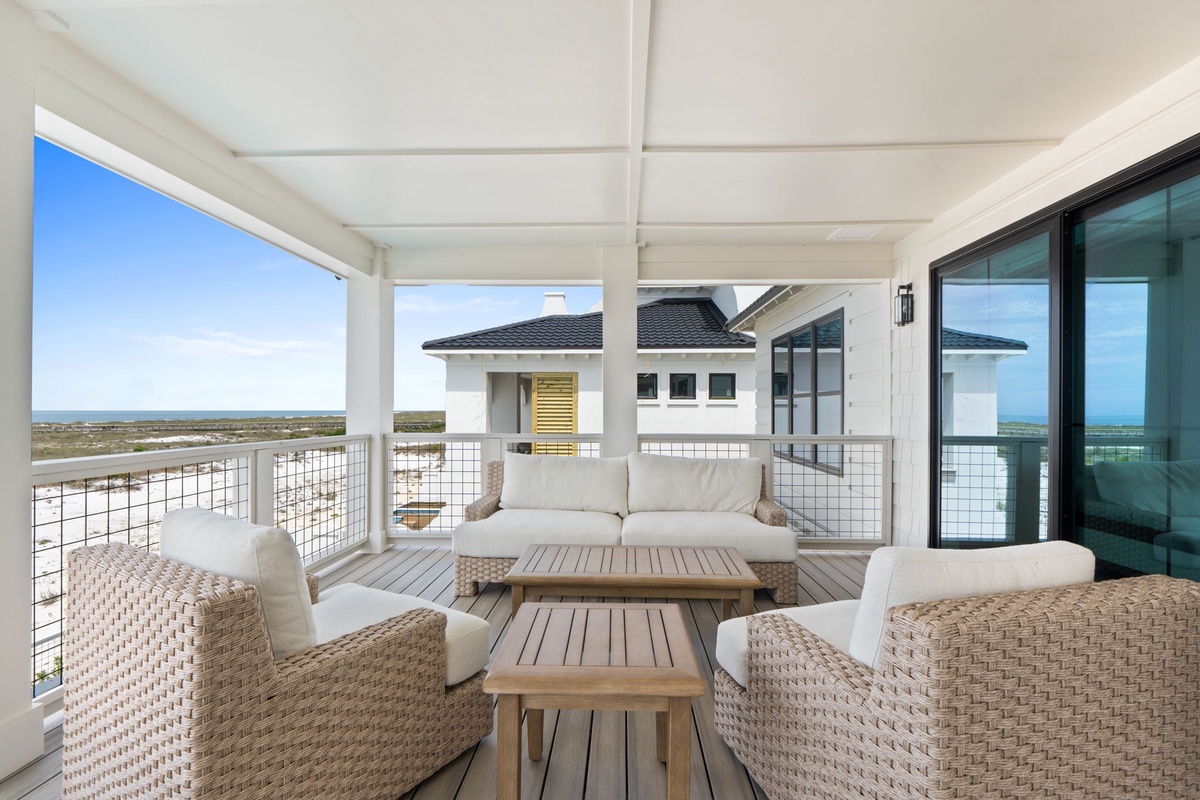 Relax on your private covered deck with stunning coastal views. The woven seating and natural wood accents invite peaceful mornings and breezy afternoons.
