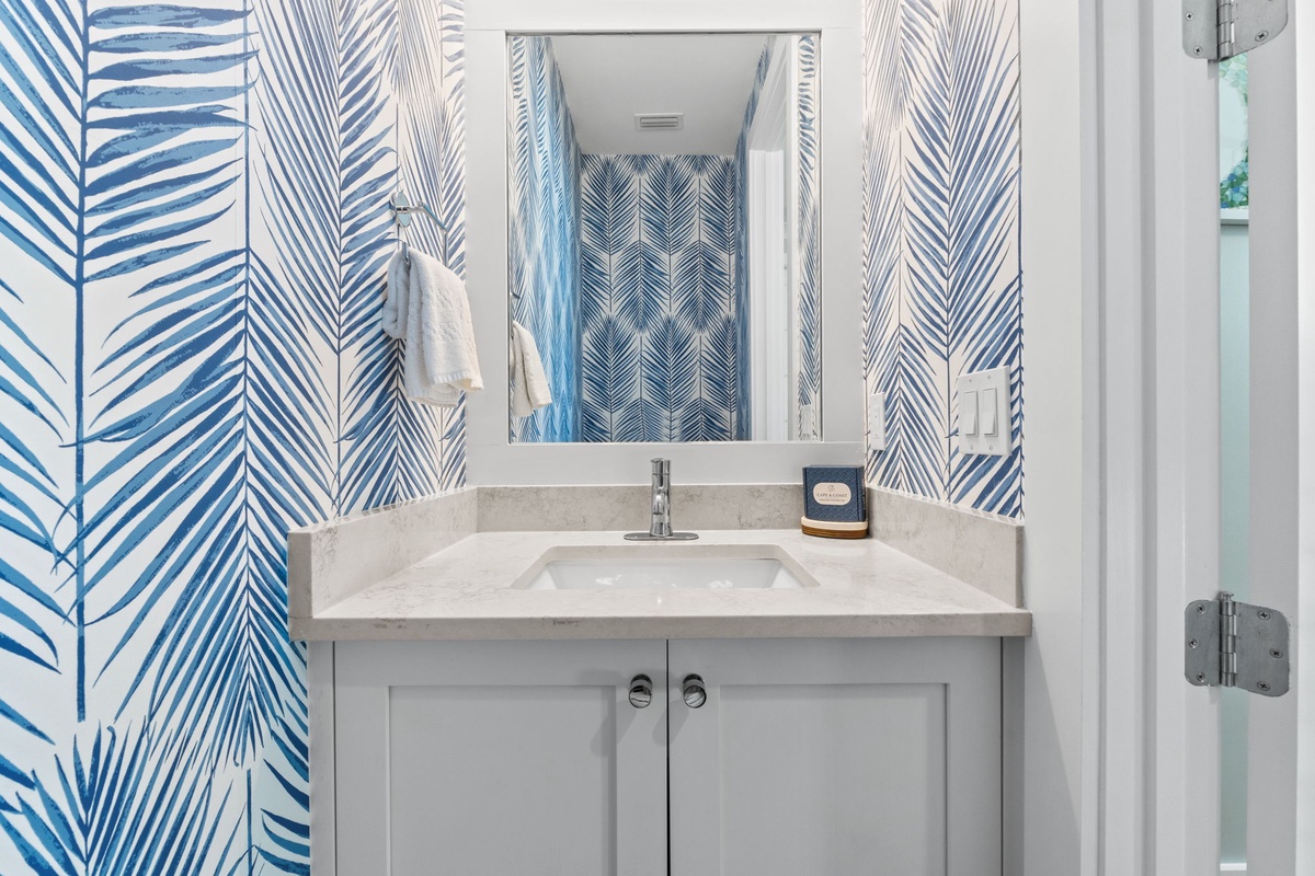 Step into your coastal-inspired ensuite with refreshing palm-patterned wallpaper, clean white cabinetry, and modern fixtures—perfect for your morning routine.