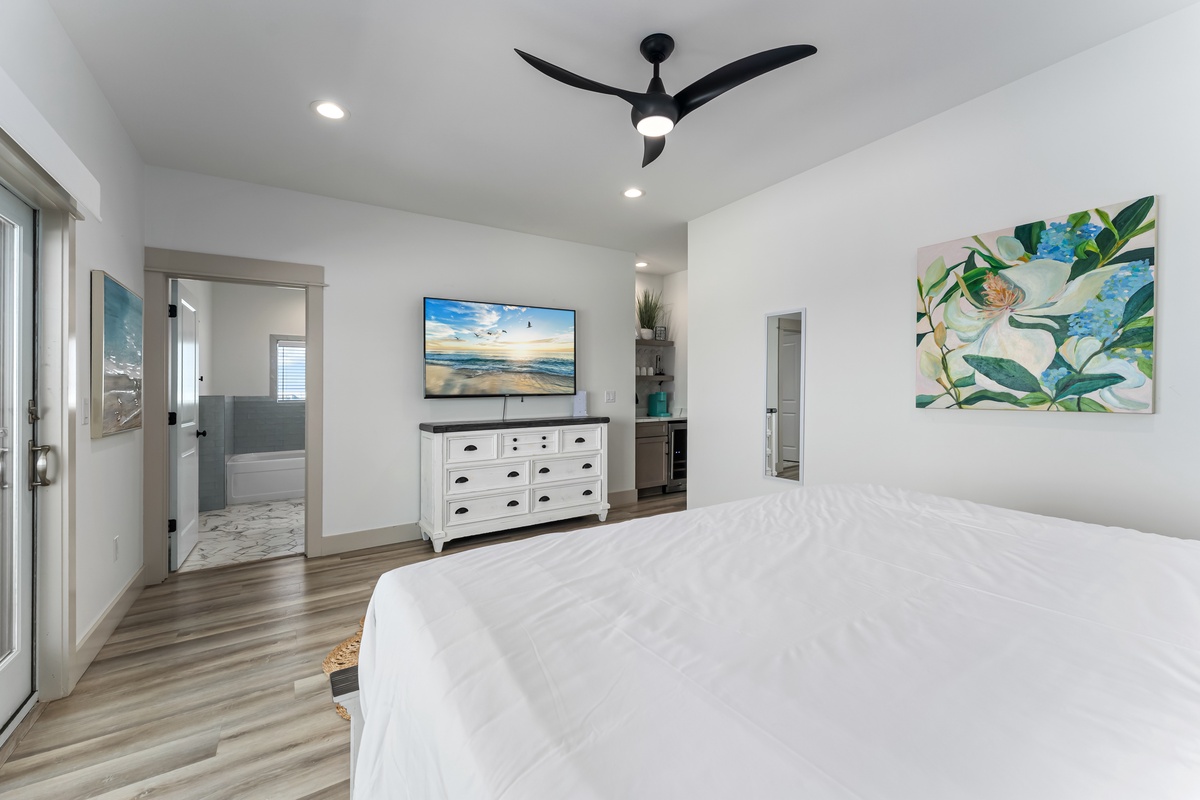 Drift off in your bright, modern bedroom with crisp linens, soothing artwork, and a ceiling fan for perfect comfort.