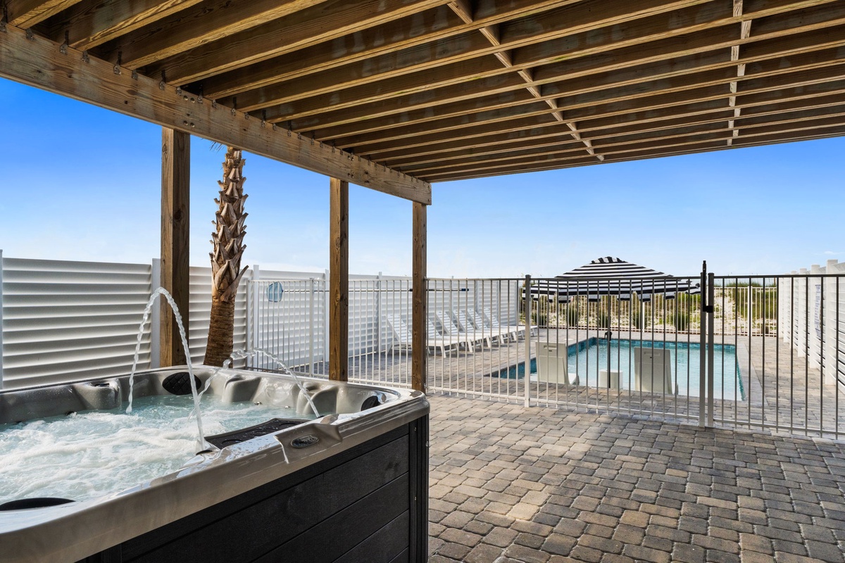 Soak in the bubbling hot tub under a shaded pergola while overlooking the sparkling pool and sunny desert landscape—your private oasis awaits.