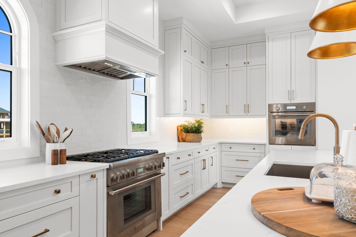 Your gourmet kitchen welcomes you with pristine white cabinetry, gleaming marble countertops, and professional-grade appliances ready for your culinary adventures.