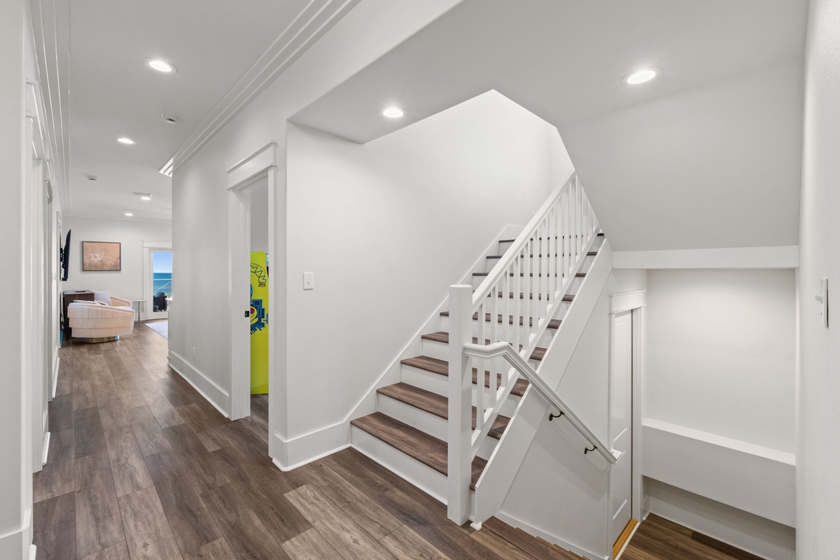Bright, airy entryway with modern staircase leads you to your comfortable retreat spaces—gleaming floors and crisp white walls create an inviting first impression.