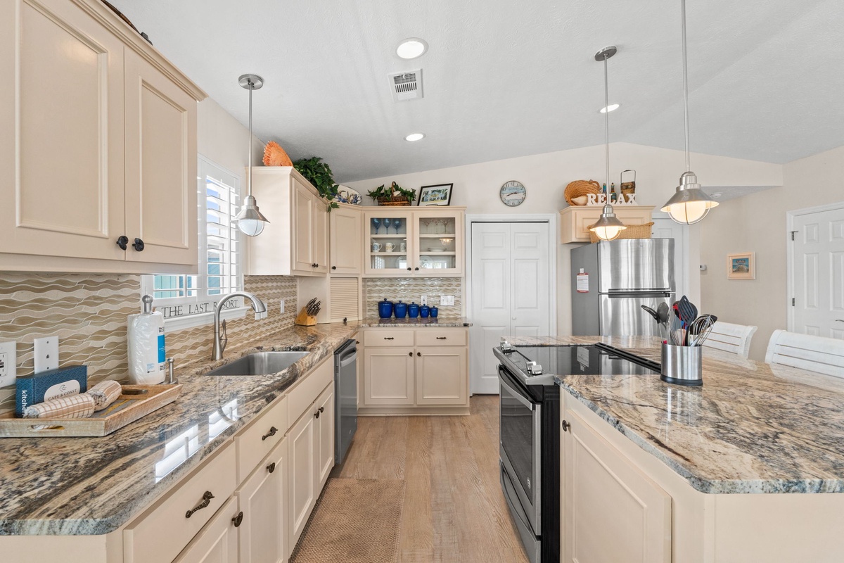 Your fully equipped kitchen features gleaming granite countertops, stainless steel appliances, and warm white cabinetry where you'll create memorable meals together.