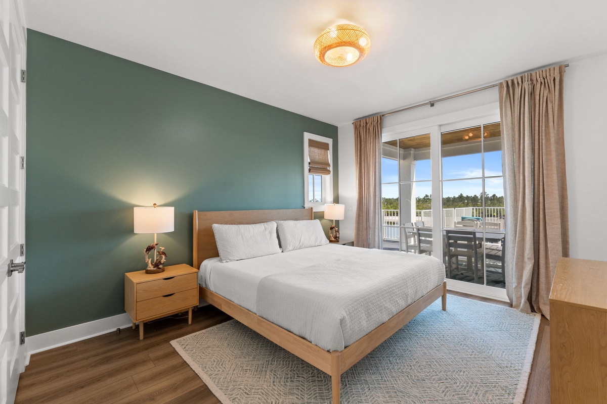 Wake up to crisp, fresh bedding and natural light streaming through your private balcony doors. The soothing sage accent wall sets the tone for a restful stay.