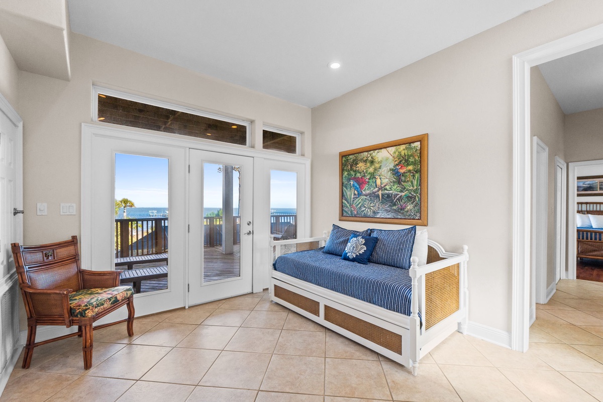 Your coastal living room opens to stunning ocean views, where blue coastal accents and tropical art create the perfect beachside retreat for relaxation.