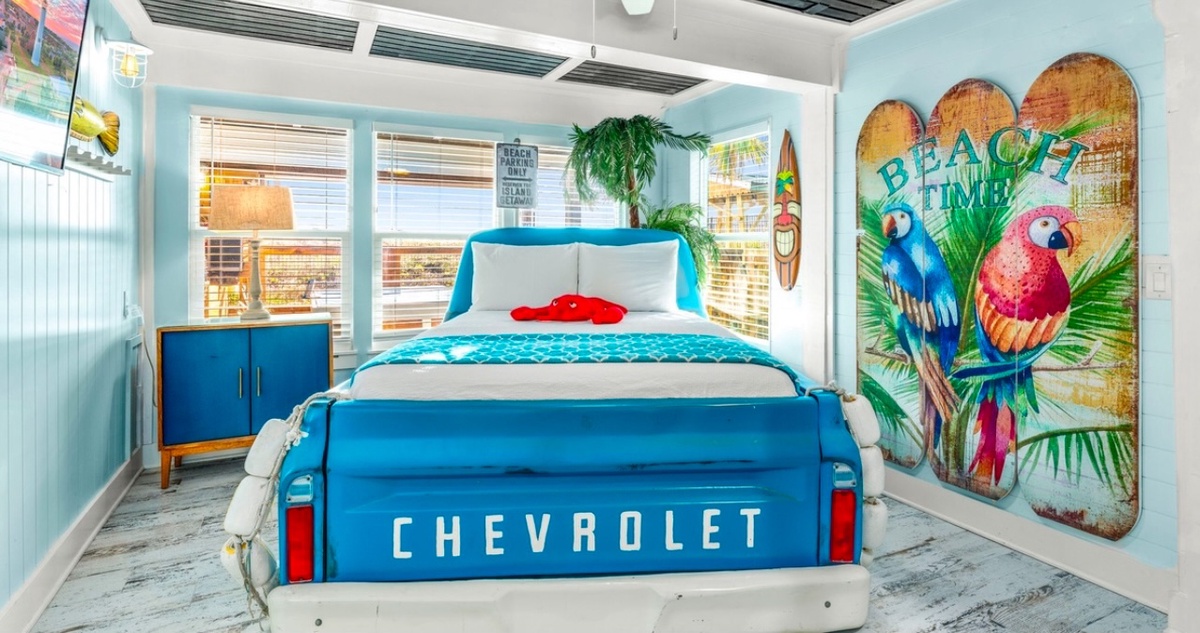 Sleep in style with this unique truck bed surrounded by tropical beach vibes and colorful parrot art.