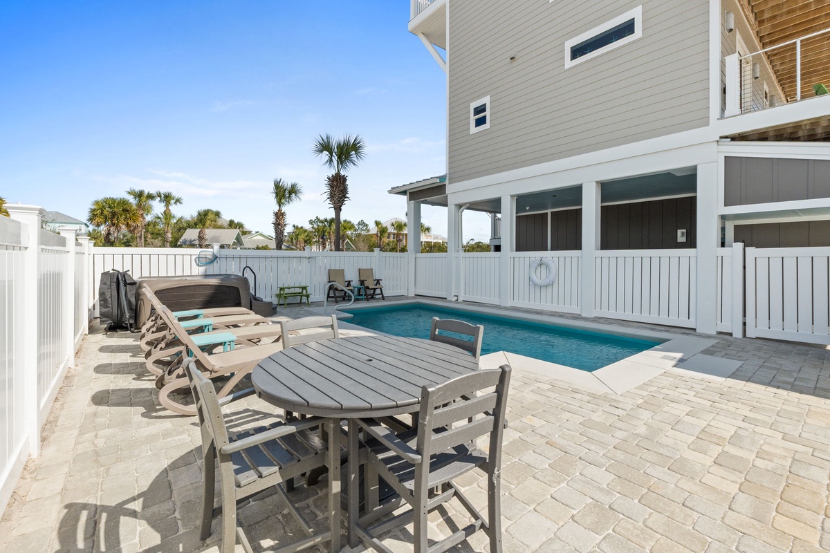 Your private poolside paradise awaits with sparkling blue water, comfortable lounge chairs, and tropical palms swaying overhead.