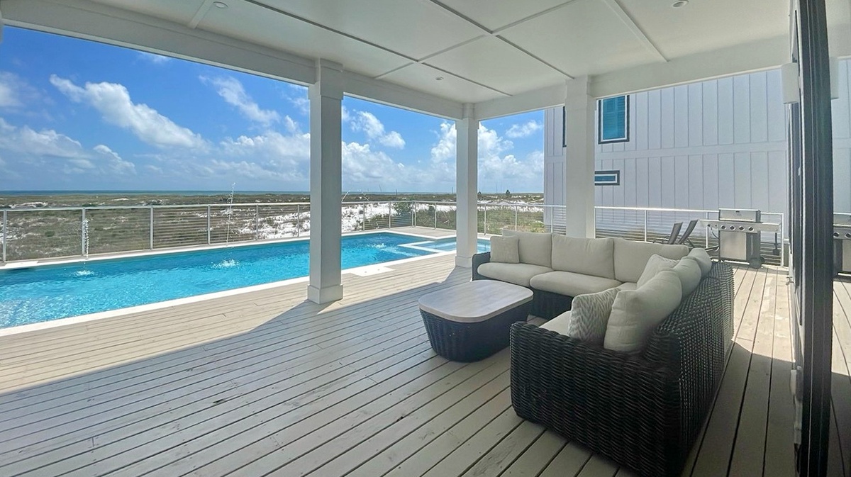 Sink into plush seating on your private deck, where stunning pool and coastal views stretch endlessly before you—perfect for morning coffee or sunset relaxation.