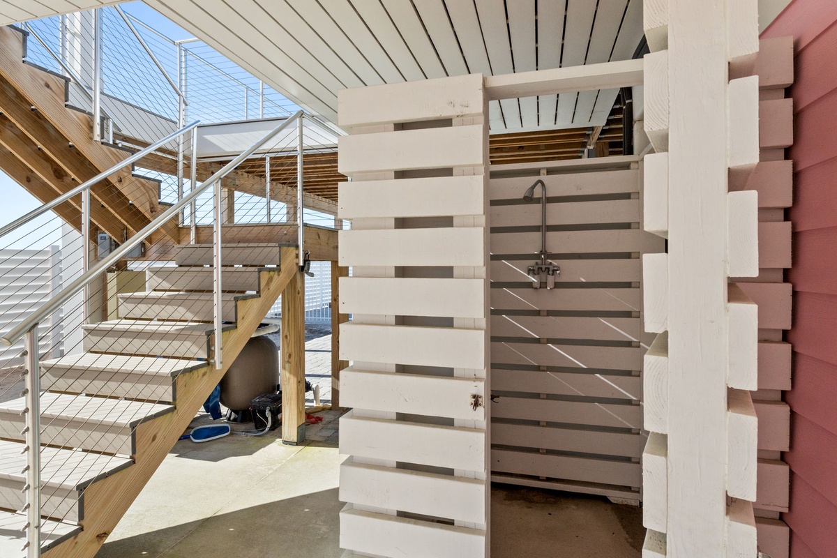 Your private outdoor shower awaits beneath modern wooden slats, offering refreshing moments after sun-soaked days on the deck.