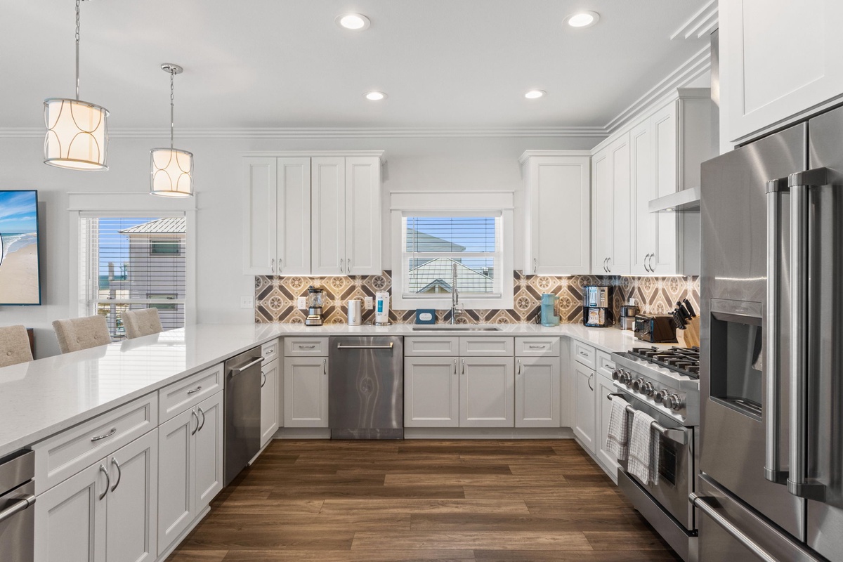 Step into your fully-equipped gourmet kitchen, where stainless steel appliances, custom cabinetry, and stylish pendant lighting create the perfect space to prepare memorable meals during your stay.
