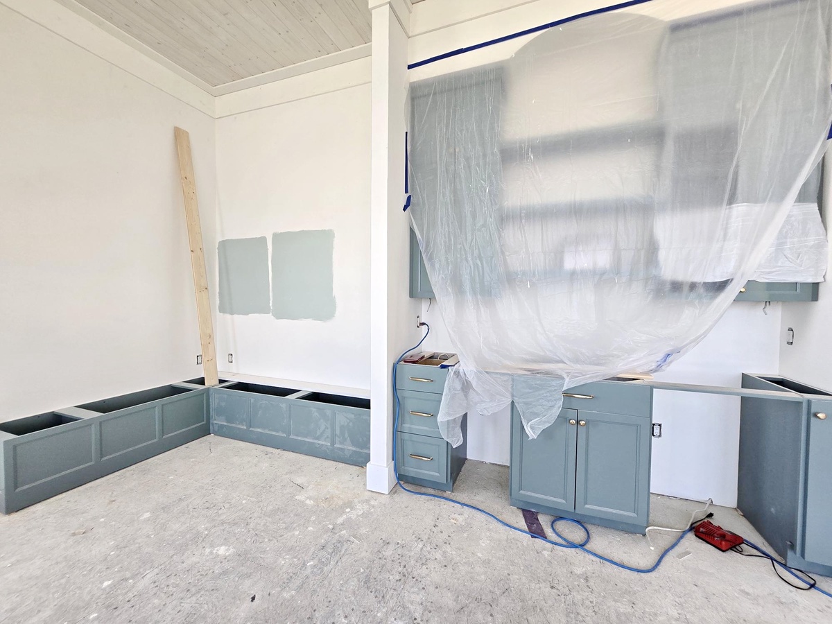 This bright kitchen is taking shape with fresh blue-gray cabinetry and crisp white walls, ready to become the heart of your coastal getaway.