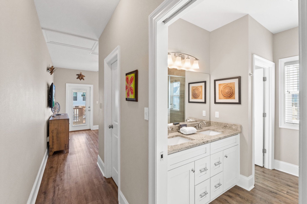 Your private vanity area features granite countertops and warm lighting, perfectly positioned between bedrooms for convenience.