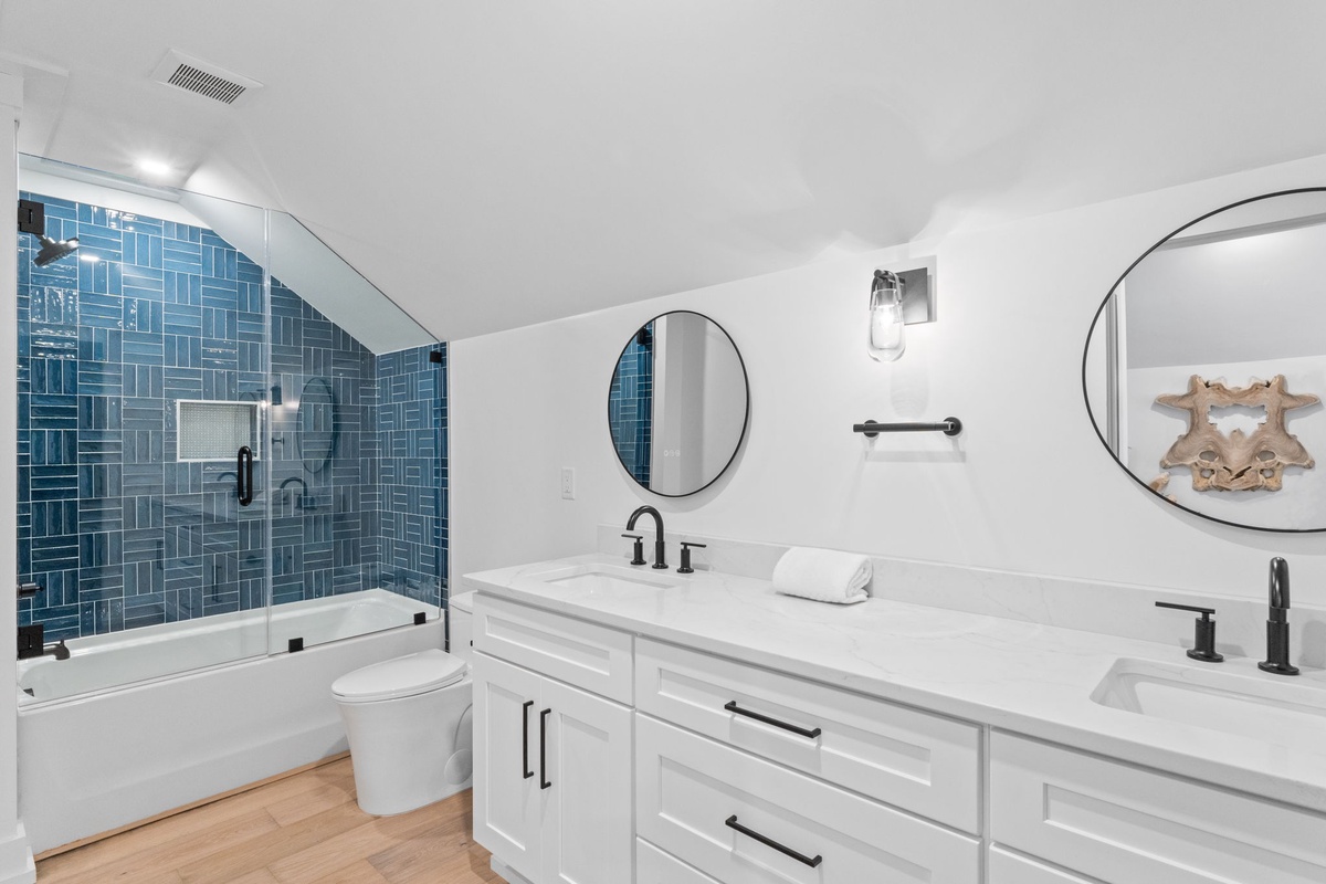 Step into your spa-like bathroom with striking blue tile, dual sinks, and a spacious tub-shower combo—your private oasis for unwinding.