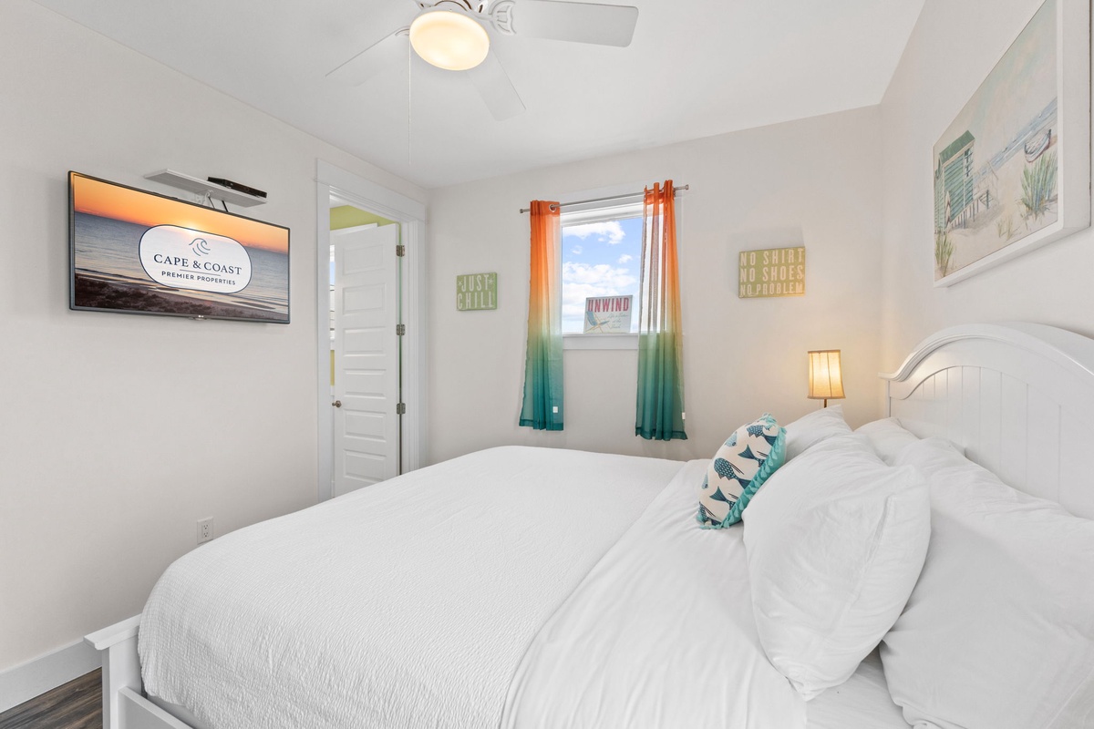 Drift into peaceful sleep in your bright bedroom, where coastal artwork and vibrant gradient curtains create a calming retreat.