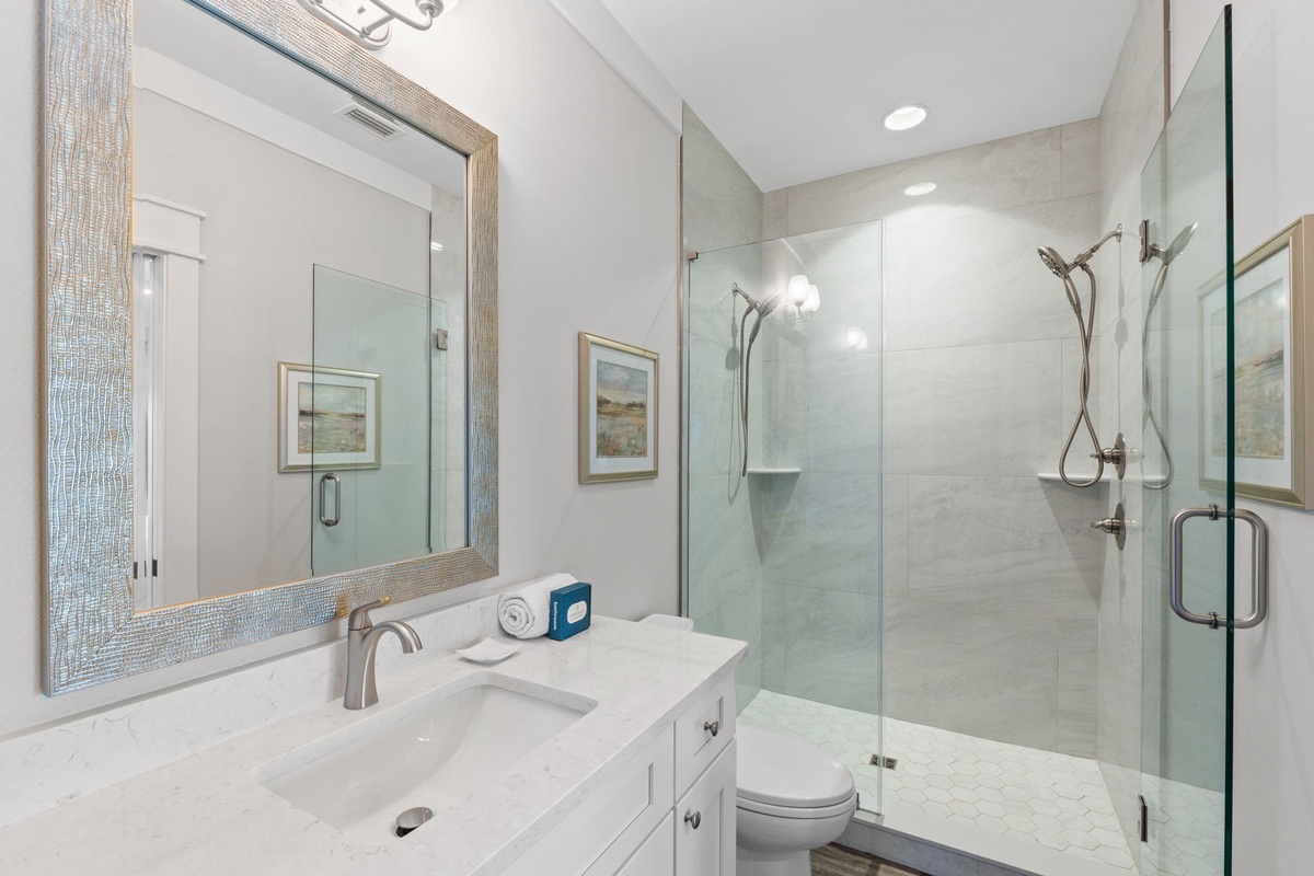 Your private bath features a spacious walk-in shower, elegant fixtures, and calming coastal tones. Refresh here after a day exploring nearby beaches and attractions.