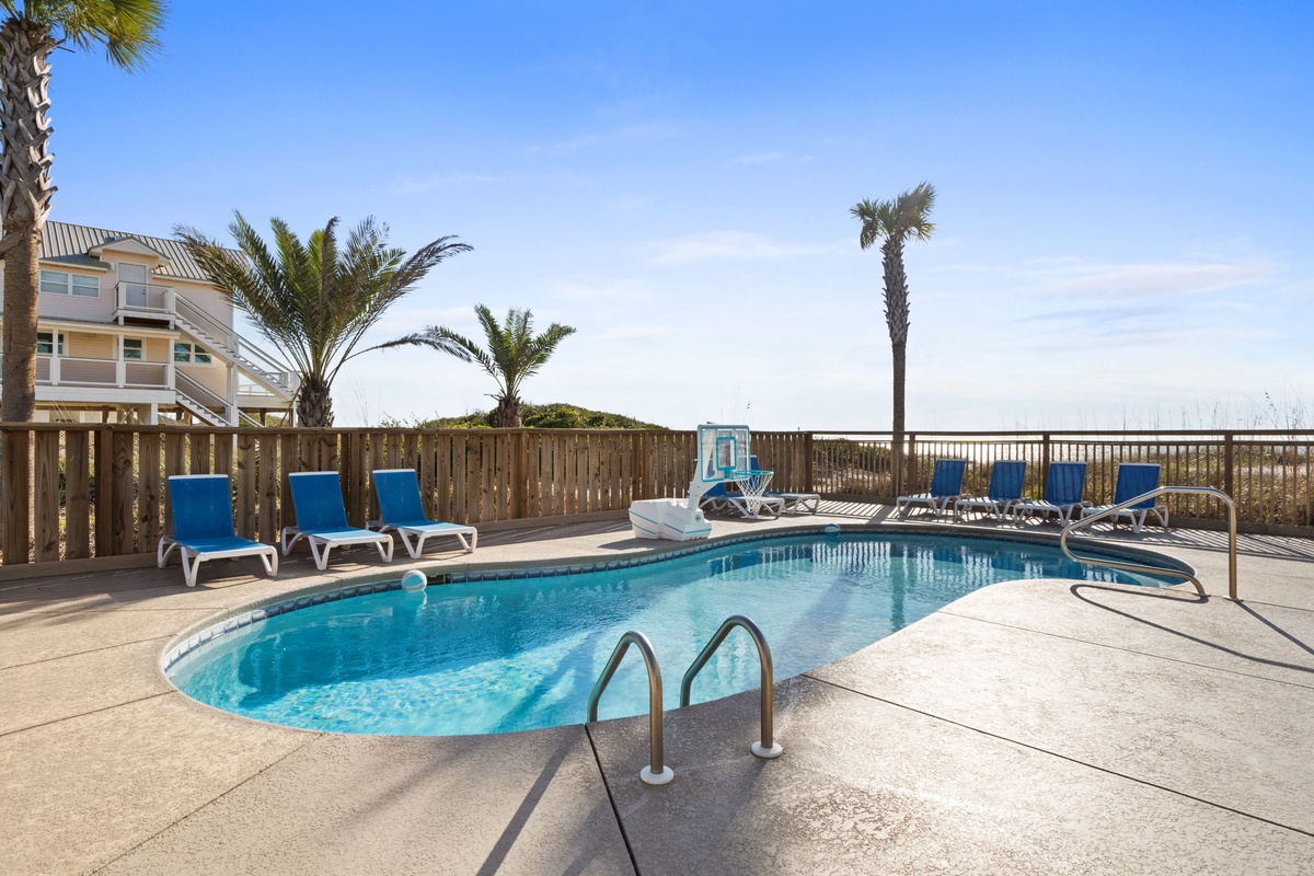 Dive into your private pool oasis surrounded by swaying palms, with comfortable loungers awaiting your perfect beach day relaxation.