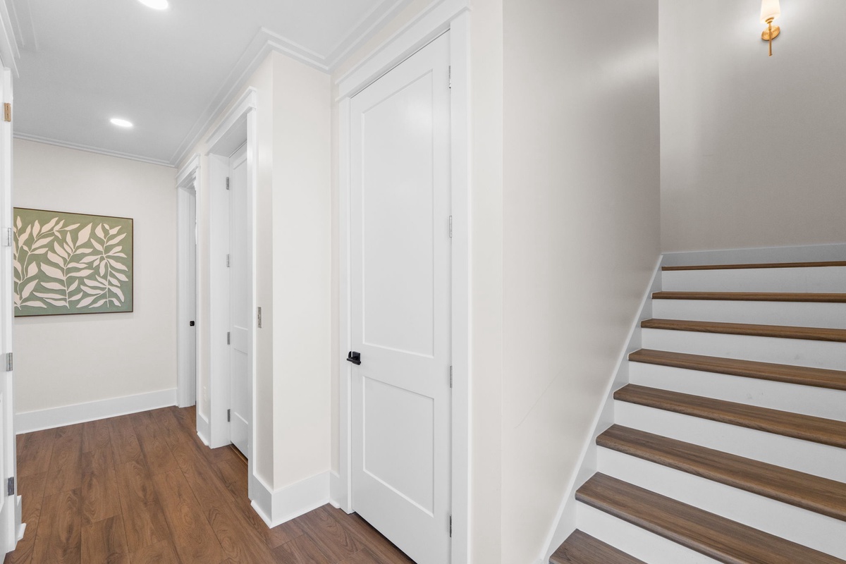 Bright hallway with warm wood floors and fresh white walls creates a welcoming entry to your upstairs retreat. Clean lines and thoughtful details make coming home feel just right.