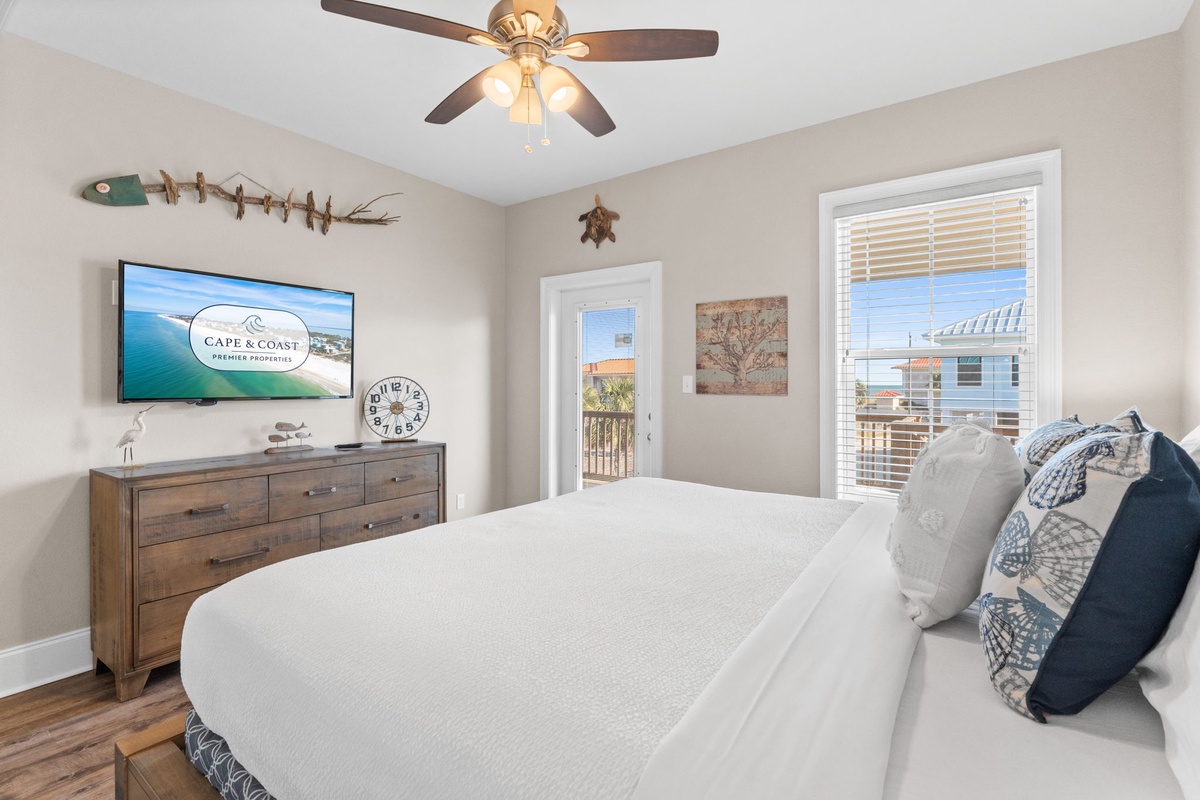 Wake up in your coastal-themed bedroom with crisp white linens, nautical touches, and balcony access for morning ocean breezes.