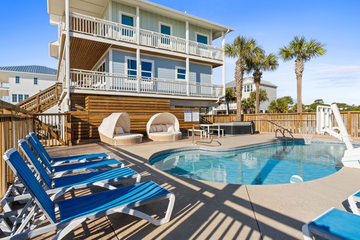 Charming coastal vacation home with private pool, elegant cabanas, and spacious balconies surrounded by swaying palms.