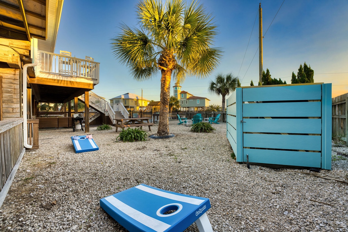 Spacious yard features cornhole games and tropical palms, perfect for outdoor gatherings