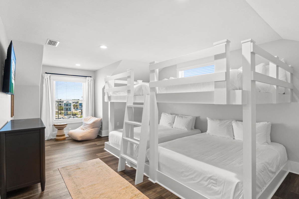 Gather the whole crew in this bright bunk room where crisp white linens and cozy beds create your family's perfect basecamp for coastal adventures.