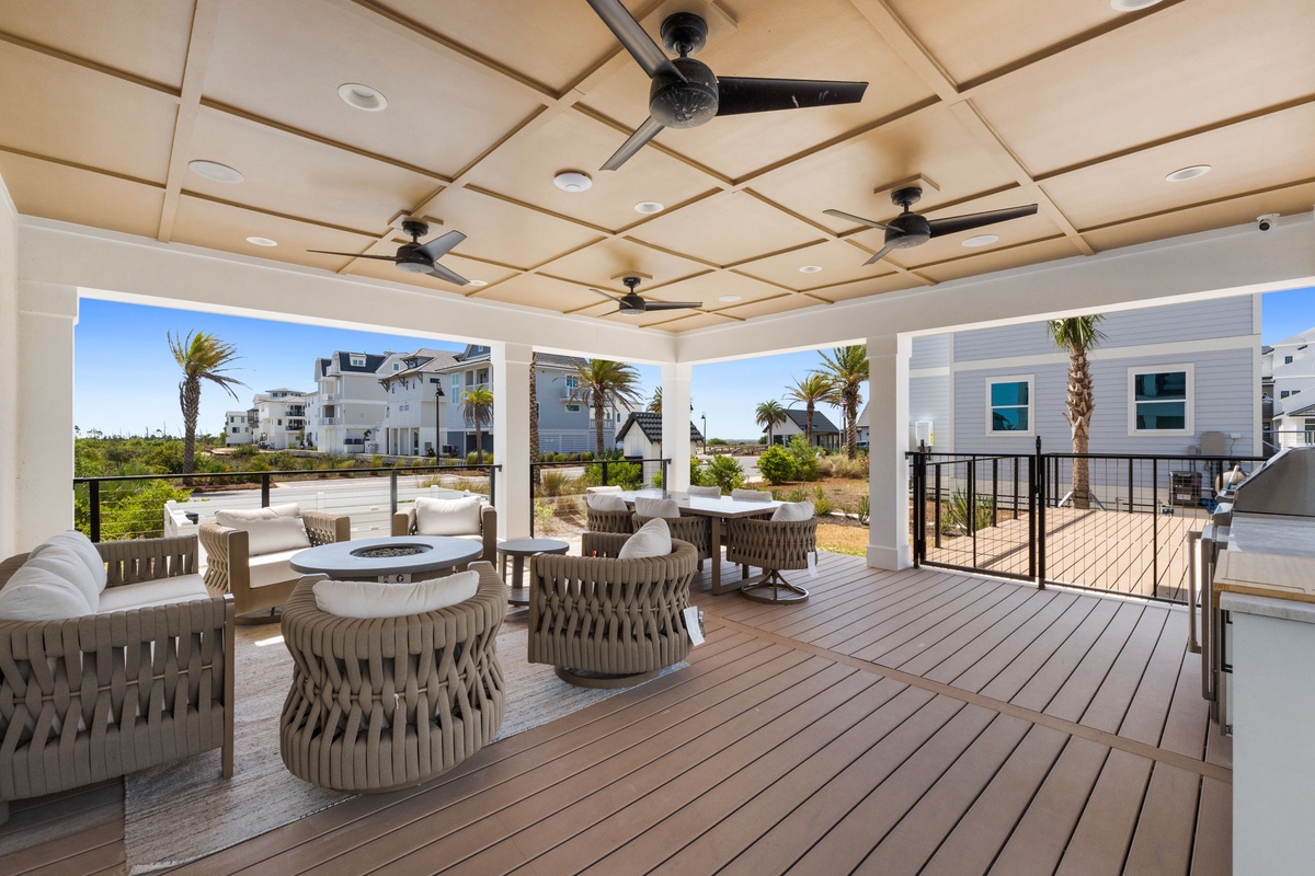 Unwind on your private covered terrace with stylish seating and ceiling fans, overlooking tropical palms and coastal community views.