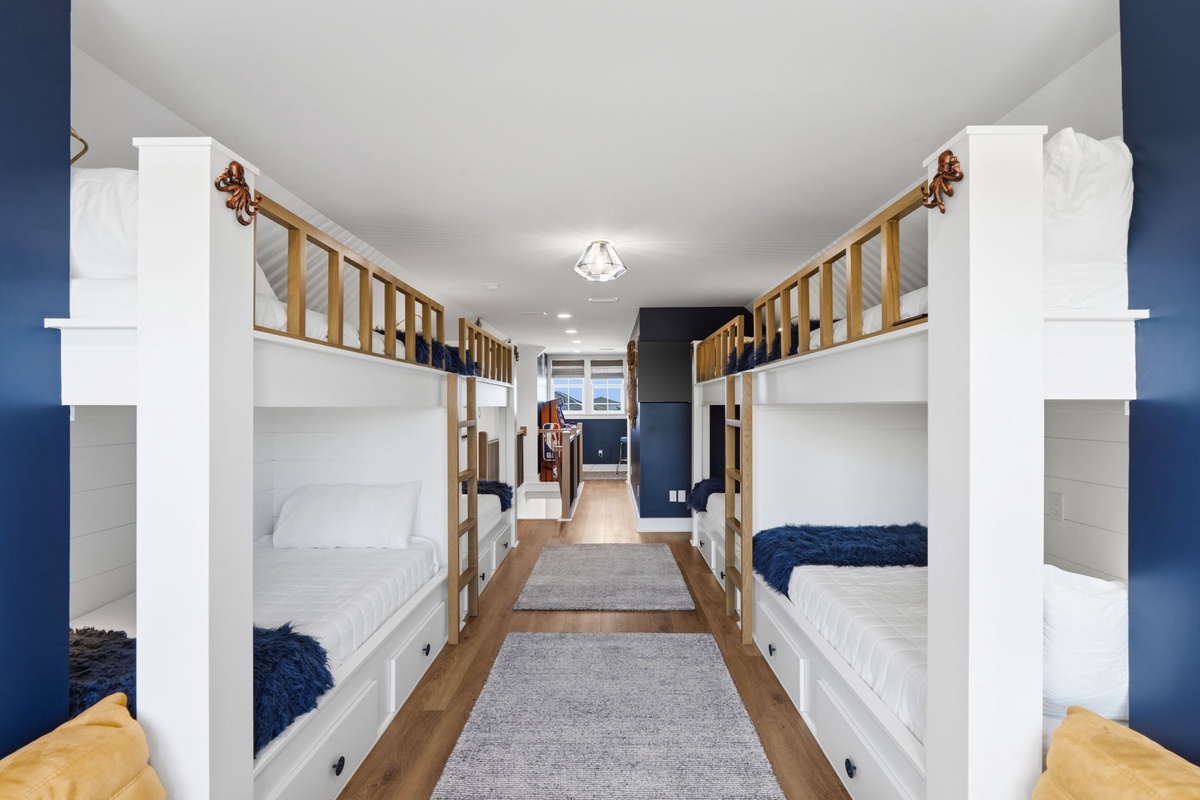 Cozy bunk room with crisp white frames and warm wood railings—perfect for your family or group to rest after a day of adventure.